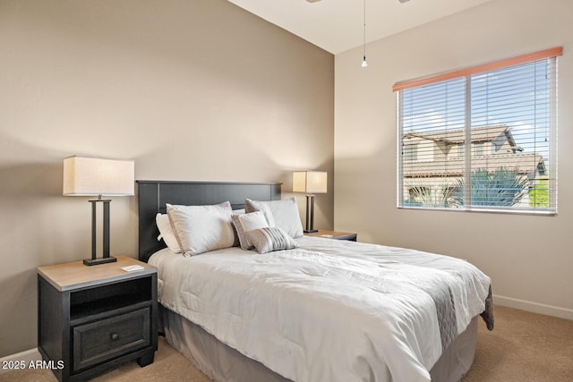 bedroom featuring light colored carpet, baseboards, and multiple windows