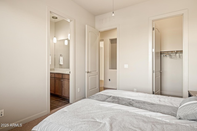 bedroom featuring connected bathroom, dark colored carpet, baseboards, visible vents, and a closet