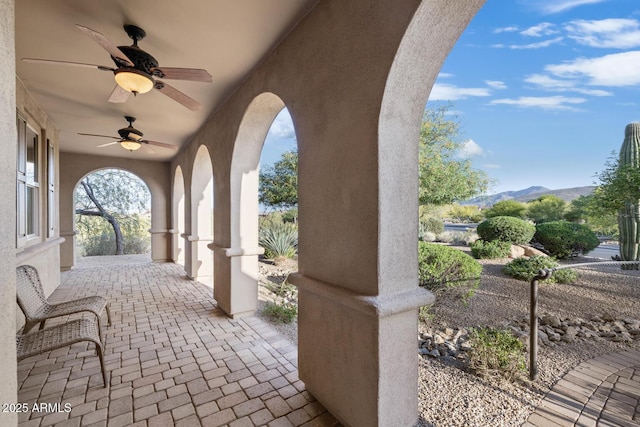 view of patio featuring ceiling fan and a mountain view
