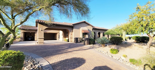 view of front facade with an attached garage, decorative driveway, stucco siding, and a tile roof