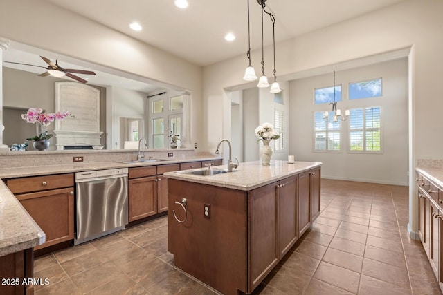 kitchen featuring stainless steel dishwasher, a sink, brown cabinets, and light stone countertops