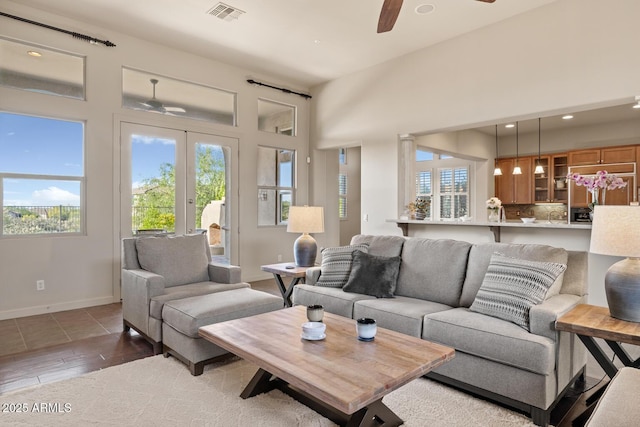living room featuring ceiling fan, visible vents, and a healthy amount of sunlight