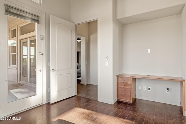 unfurnished office featuring baseboards and dark wood-style floors