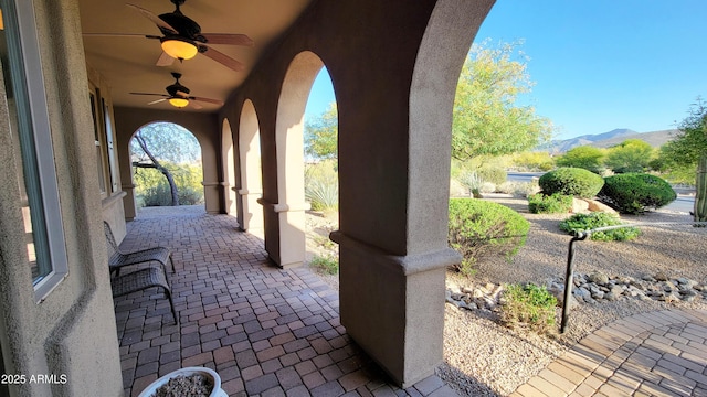 view of patio featuring a ceiling fan and a mountain view