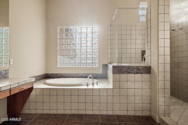 bathroom with a walk in shower, tile patterned flooring, and a bath
