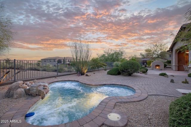 view of pool with a fenced in pool, a lit fireplace, fence private yard, and a patio area