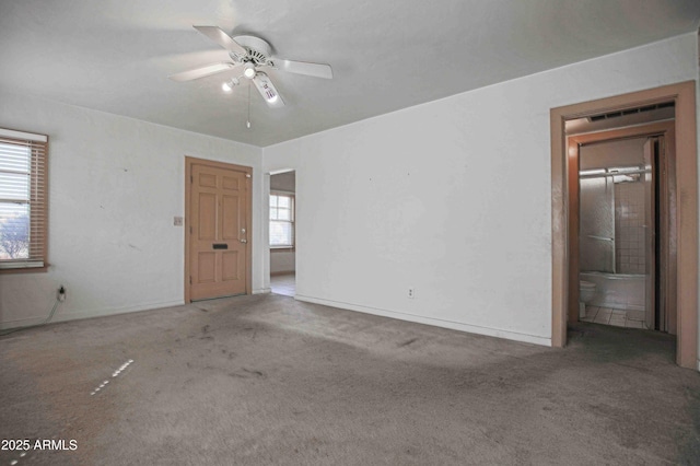 carpeted empty room with ceiling fan and baseboards