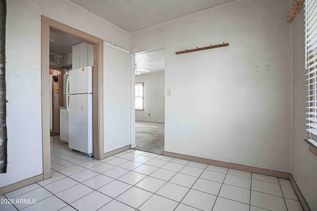 empty room with baseboards and light tile patterned floors