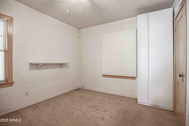 spare room featuring light carpet and a ceiling fan