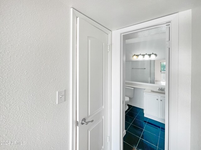 bathroom featuring tile patterned flooring, vanity, and toilet