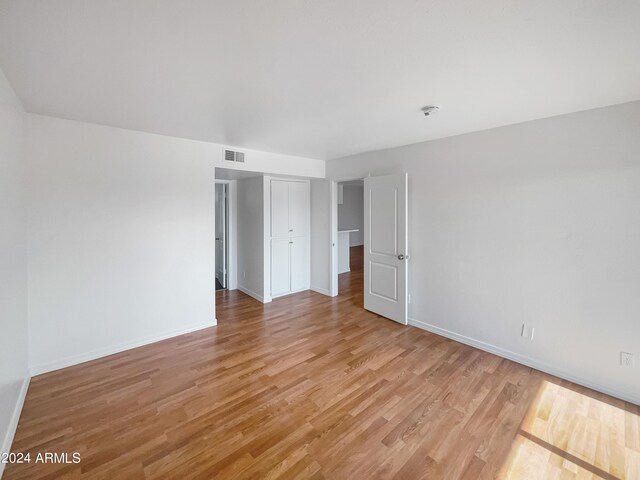 unfurnished bedroom featuring light hardwood / wood-style floors and a closet