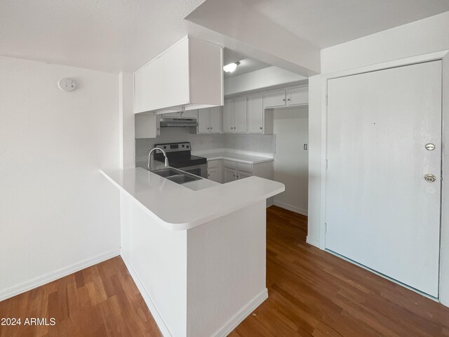 kitchen featuring sink, hardwood / wood-style flooring, white cabinetry, stainless steel electric range oven, and kitchen peninsula