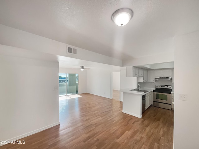 kitchen featuring hardwood / wood-style flooring, sink, stainless steel range with electric cooktop, and kitchen peninsula