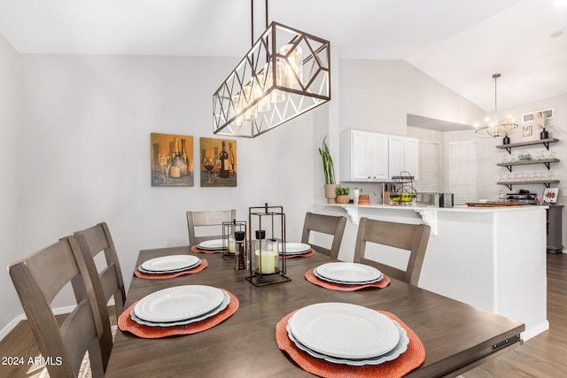 dining area with light hardwood / wood-style floors, lofted ceiling, and a notable chandelier