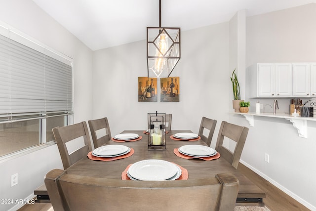 dining space featuring wood-type flooring and lofted ceiling