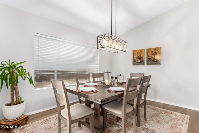 dining area featuring vaulted ceiling, a chandelier, and hardwood / wood-style flooring