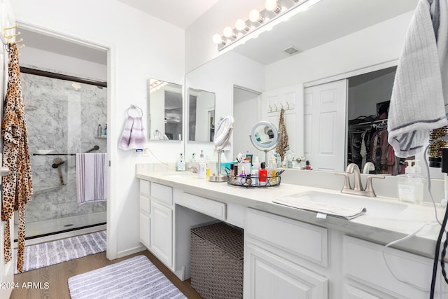 bathroom featuring walk in shower, vanity, and hardwood / wood-style flooring