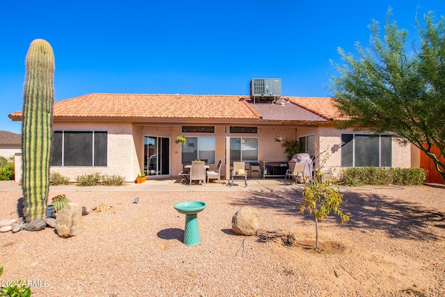 rear view of house with central AC and a patio area