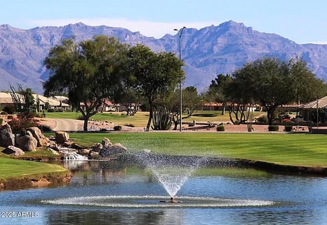 view of property's community featuring a water and mountain view and a yard