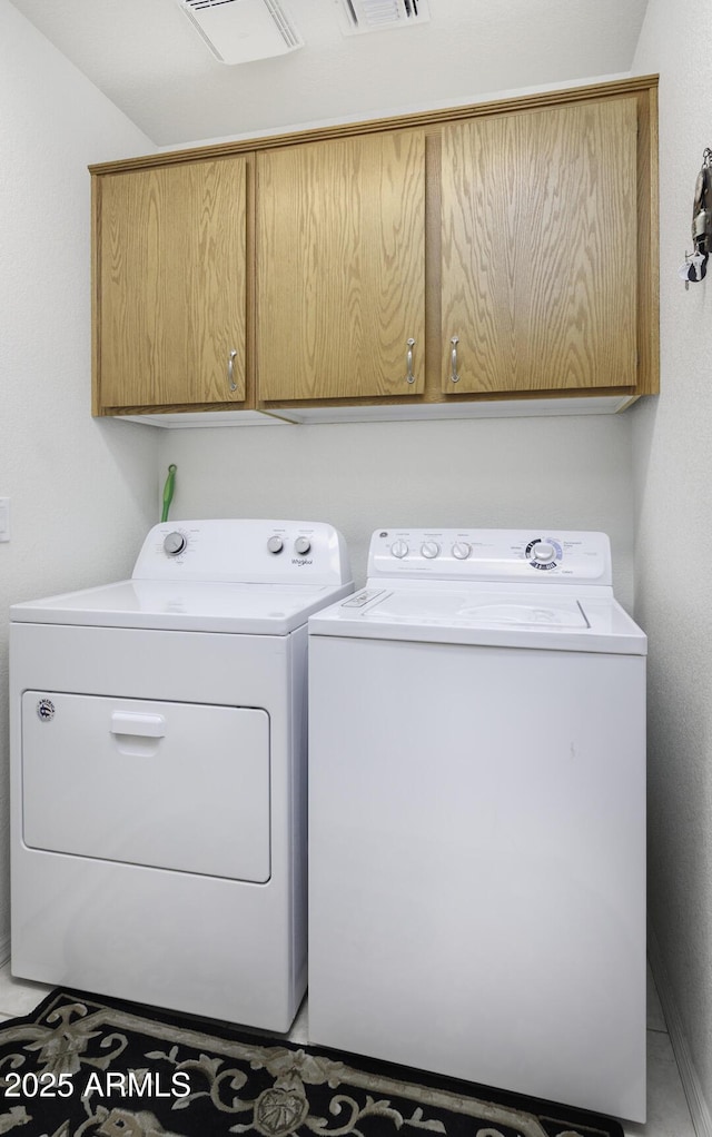 laundry area with independent washer and dryer and cabinets