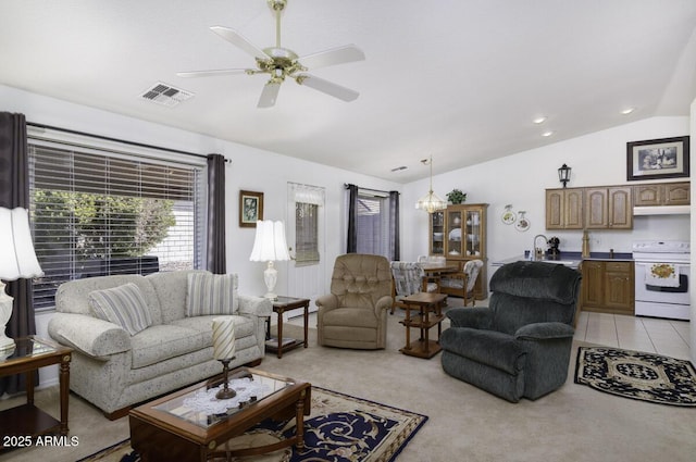 living room featuring lofted ceiling, light tile patterned floors, sink, and ceiling fan