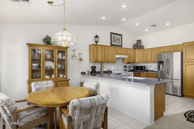 kitchen with lofted ceiling, decorative light fixtures, appliances with stainless steel finishes, kitchen peninsula, and a notable chandelier