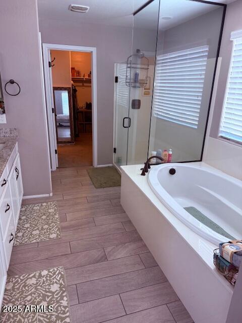 10335 W Pima St, Tolleson, AZ 85353 - bathroom featuring a stall shower, a bath, vanity, a walk in closet, and healthy amount of natural light