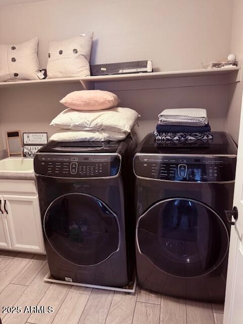 10335 W Pima St, Tolleson, AZ 85353 - laundry room with light wood-style flooring, cabinet space, and washing machine and clothes dryer