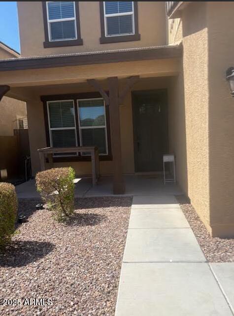 10335 W Pima St, Tolleson, AZ 85353 - view of exterior entry with stucco siding and a porch