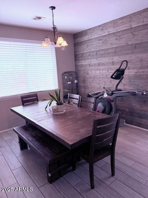 10335 W Pima St, Tolleson, AZ 85353 - dining room with wood finished floors, a chandelier, and wooden walls