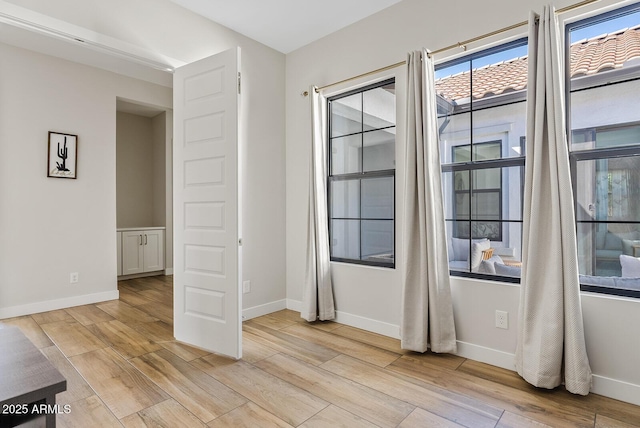 interior space with baseboards and light wood-style flooring