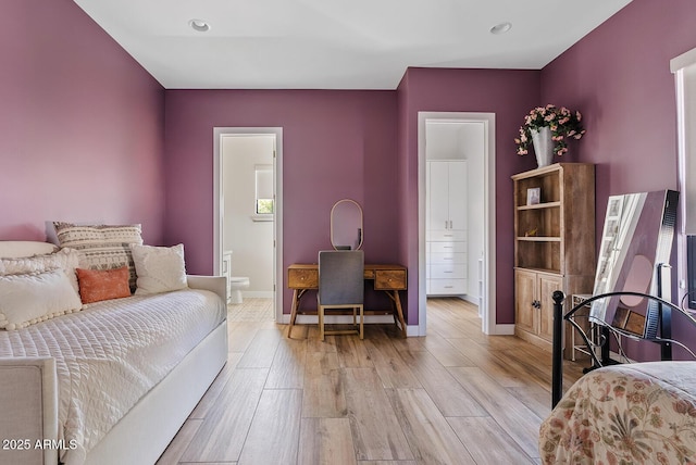bedroom featuring light wood-type flooring, recessed lighting, baseboards, and ensuite bath