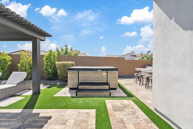 view of yard with a patio, a fenced backyard, a hot tub, and outdoor dry bar
