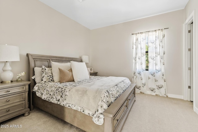 bedroom with light colored carpet and baseboards