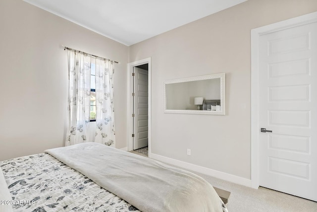bedroom with baseboards and light carpet