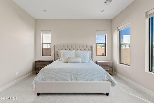 carpeted bedroom featuring visible vents, baseboards, and multiple windows