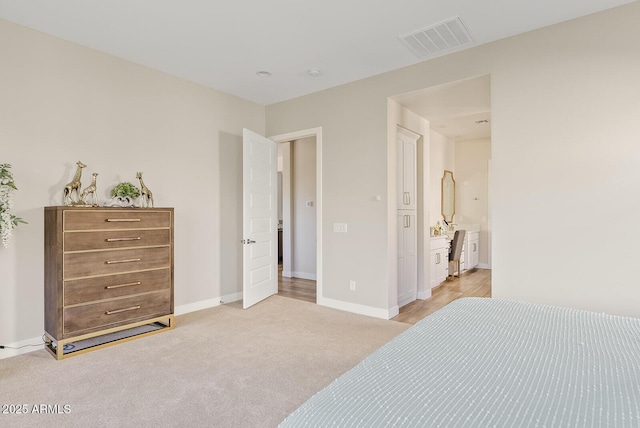 bedroom with baseboards, visible vents, and light carpet