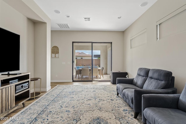 living area with baseboards, recessed lighting, wood finished floors, and visible vents