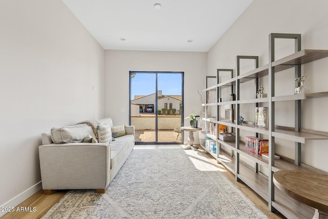 living area with baseboards and wood finished floors