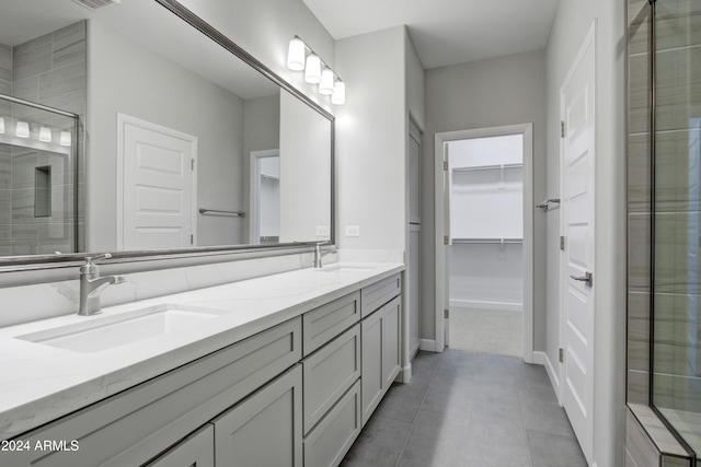 bathroom featuring tile patterned flooring, vanity, and a shower with door