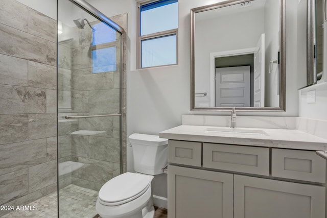 bathroom with vanity, toilet, and an enclosed shower