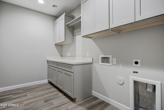 laundry room featuring cabinets, washer hookup, light wood-type flooring, and electric dryer hookup