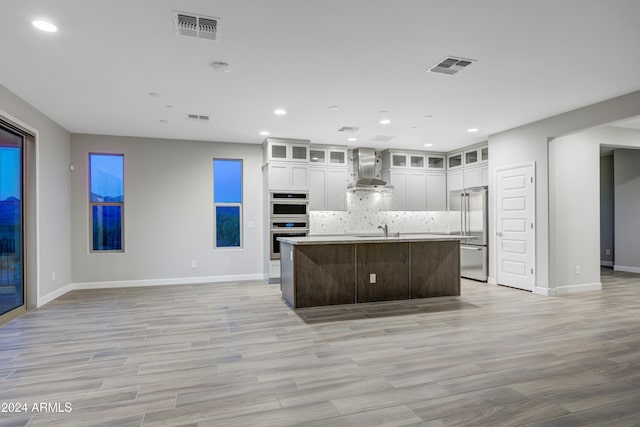 kitchen featuring white cabinetry, sink, an island with sink, decorative backsplash, and appliances with stainless steel finishes