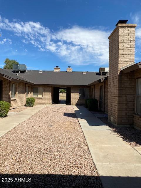 27 W Concorda Dr Unit 104, Tempe, AZ 85282 - view of front of home featuring a chimney, central AC, and brick siding
