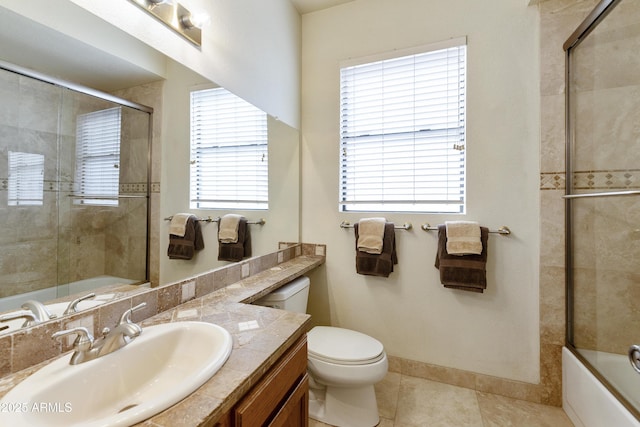 full bathroom featuring toilet, enclosed tub / shower combo, vanity, tile patterned flooring, and baseboards