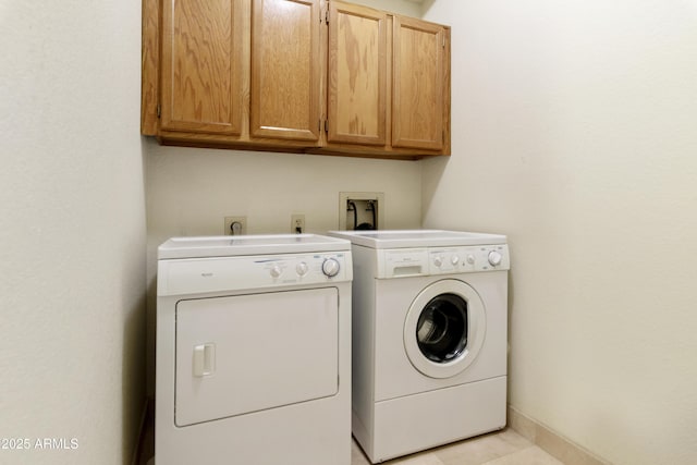 washroom featuring independent washer and dryer, cabinet space, and baseboards