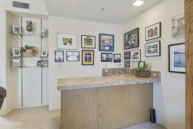 bar with light carpet, a sink, visible vents, and wet bar