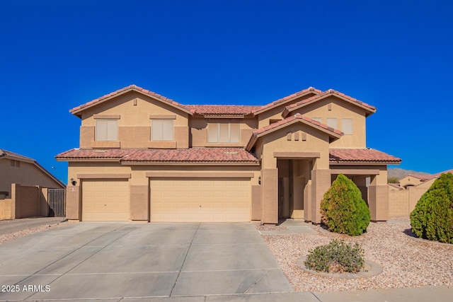 mediterranean / spanish-style home with a garage, fence, driveway, and stucco siding