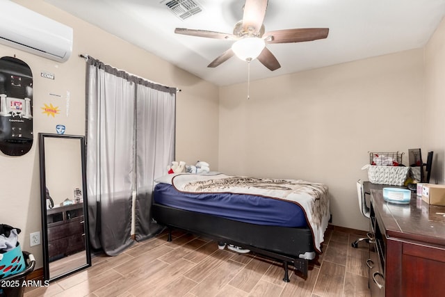 bedroom with wood tiled floor, visible vents, a ceiling fan, and a wall mounted AC