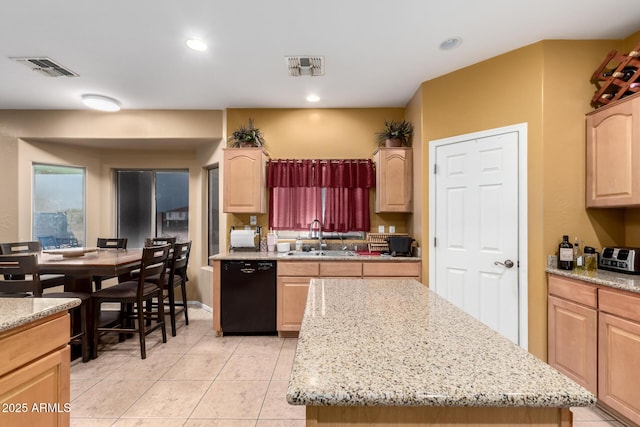 kitchen with light brown cabinets, dishwasher, and a sink